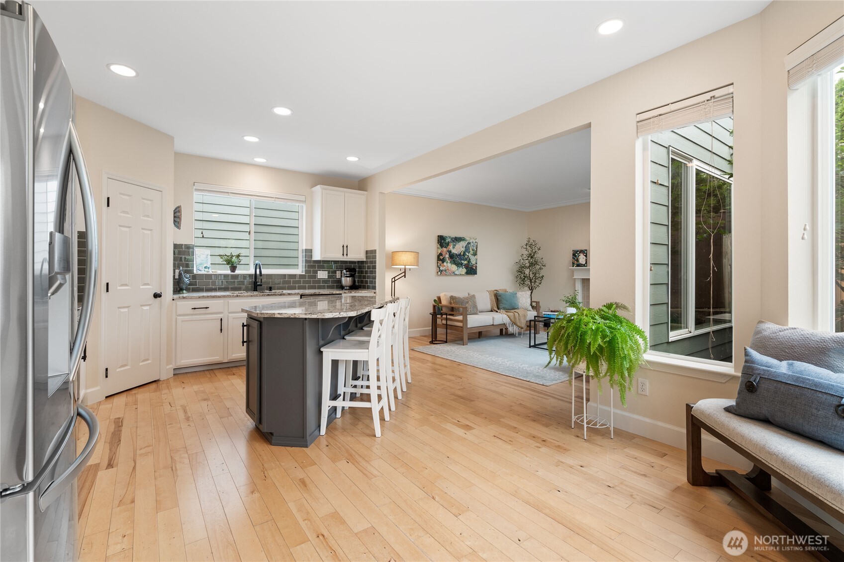 21104 1st Avenue West Bothell, WA 98021 - Photo 9 of 34 a kitchen with stainless steel appliances kitchen island granite countertop a table chairs refrigerator a stove a sink and dishwasher with wooden floor