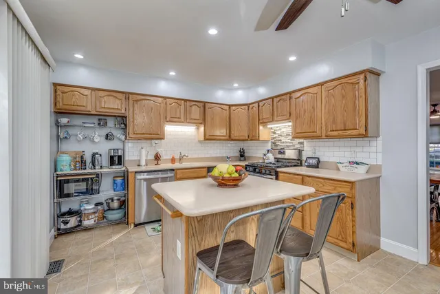 a kitchen with a sink a stove and chairs