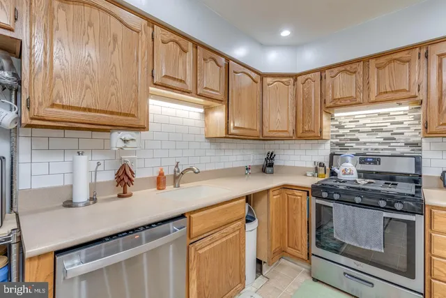 a kitchen with stainless steel appliances granite countertop a sink a stove and cabinets