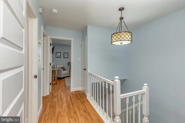 a view of a hallway with wooden floor and dining room