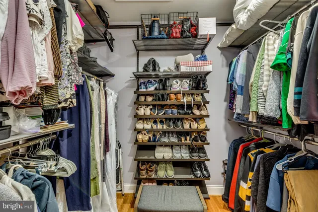 a view of walk in closet with clothes and shoes