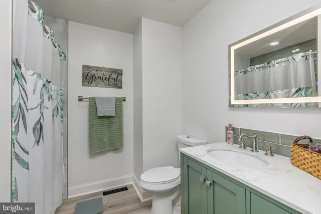 a bathroom with a granite countertop toilet sink and mirror