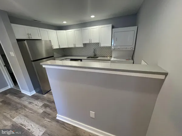 a kitchen with stainless steel appliances a sink stove refrigerator and cabinets