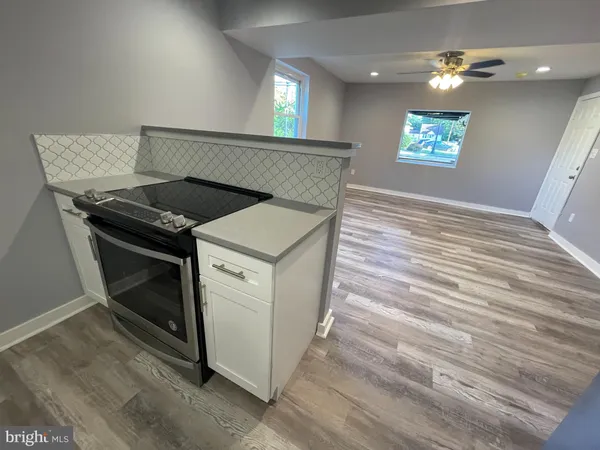a kitchen with a stove and hallway