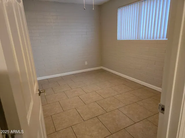 an empty room with wooden floor and mirror