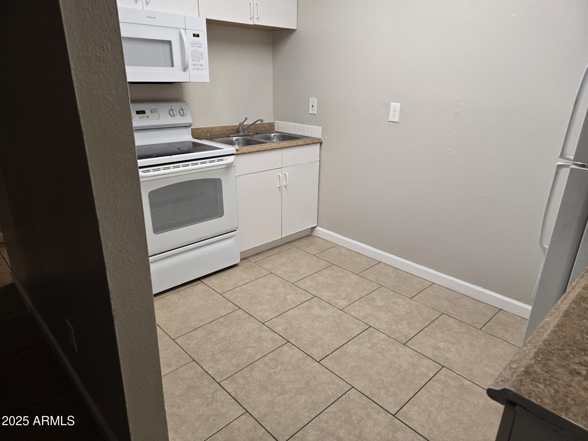 902 East Southern Avenue, Unit 2 Phoenix, AZ 85040 - Photo 4 of 25 a kitchen with granite countertop white cabinets and white appliances