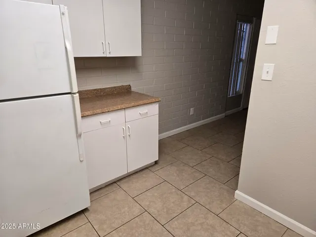 a white refrigerator freezer and a stove sitting inside of a kitchen