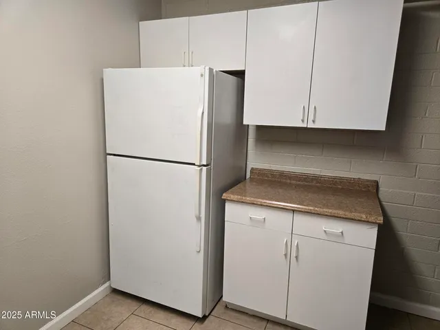 a kitchen with white cabinets and white appliances