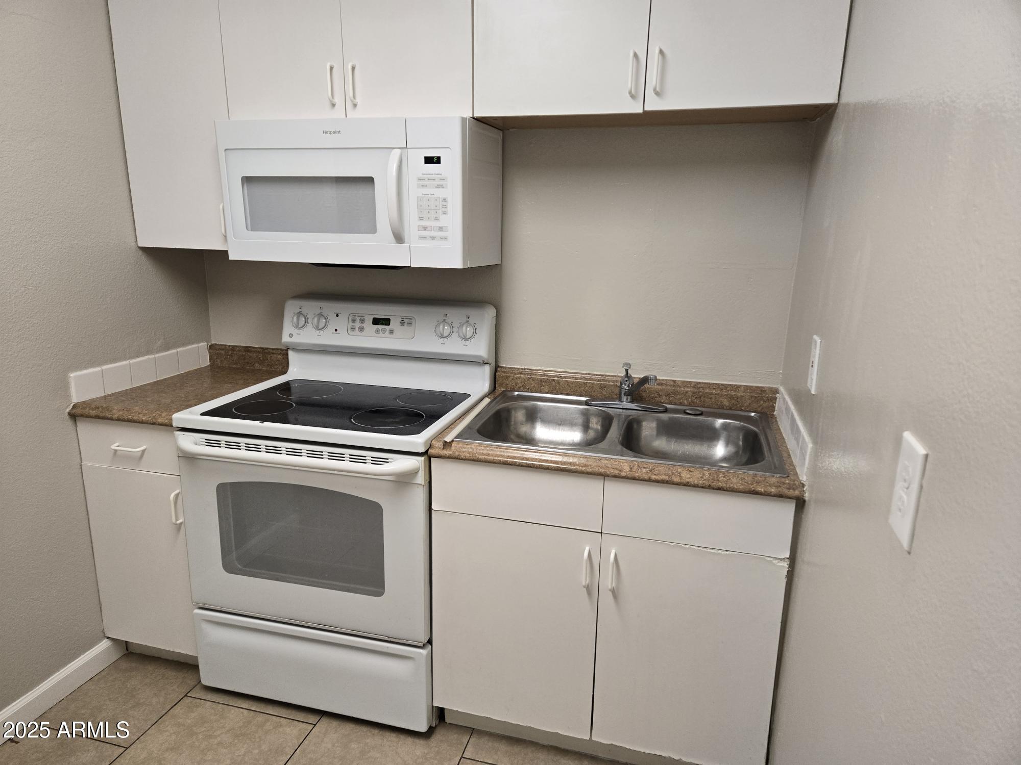 902 East Southern Avenue, Unit 2 Phoenix, AZ 85040 - Photo 7 of 25 a kitchen with white cabinets and white appliances