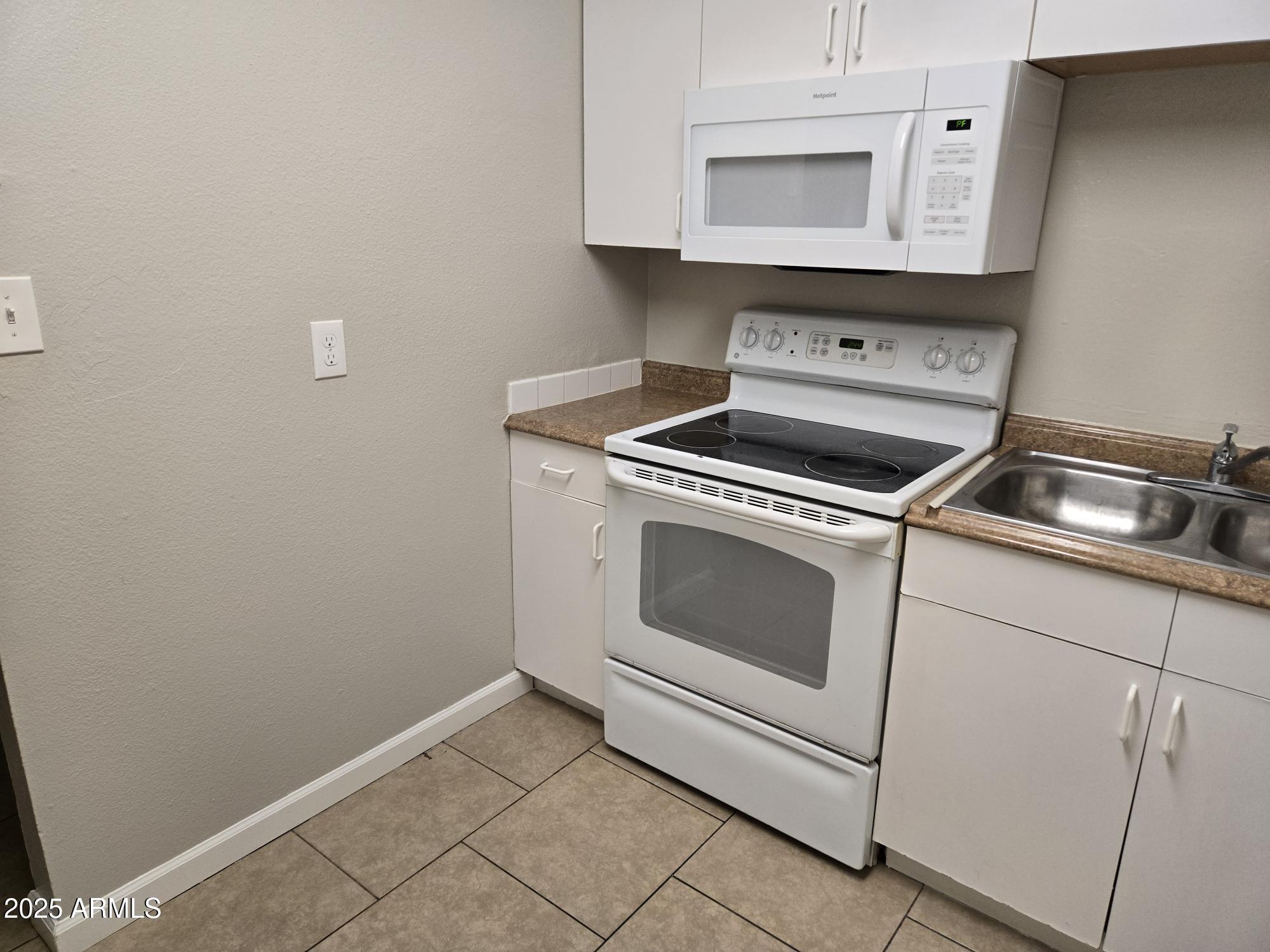 902 East Southern Avenue, Unit 2 Phoenix, AZ 85040 - Photo 9 of 25 a kitchen with granite countertop white cabinets and white appliances