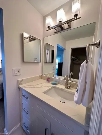 a bathroom with a sink vanity and mirror