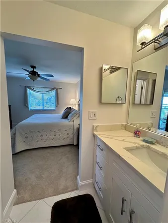 a en suite bathroom with a granite countertop sink and a mirror