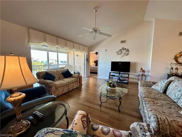 a living room with furniture a flat screen tv and a large window