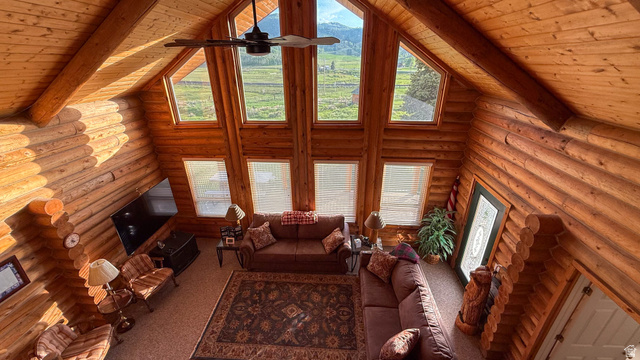 143 East Chestnut Street Helper, UT 84526 - Photo 21 of 35 Living room with rustic walls, a high wooden beamed ceiling, carpet flooring, and a ceiling fan