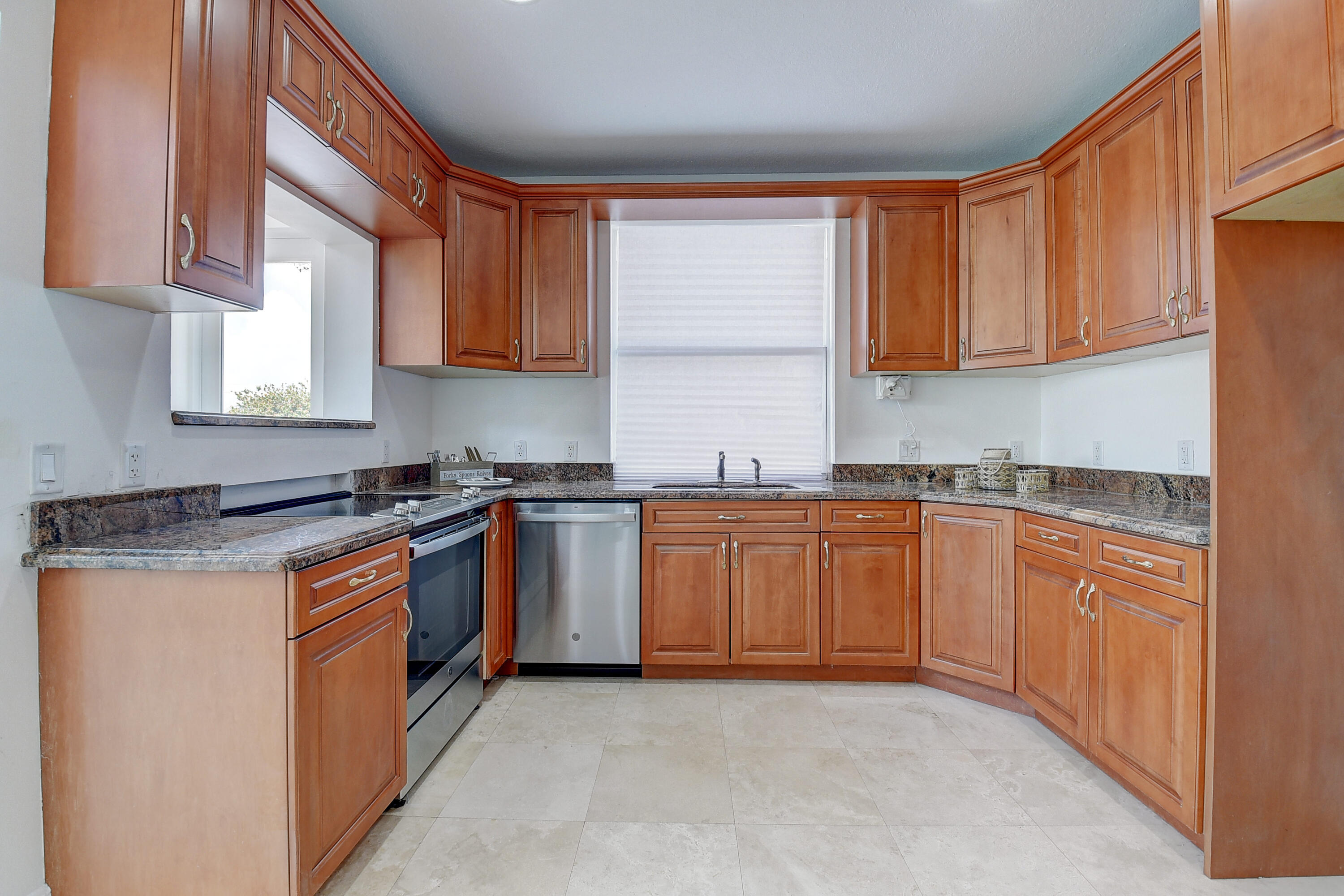 9058 Southwest 4th Street Boca Raton, FL 33433 - Photo 17 of 53 a kitchen with stainless steel appliances granite countertop a stove a sink and a microwave
