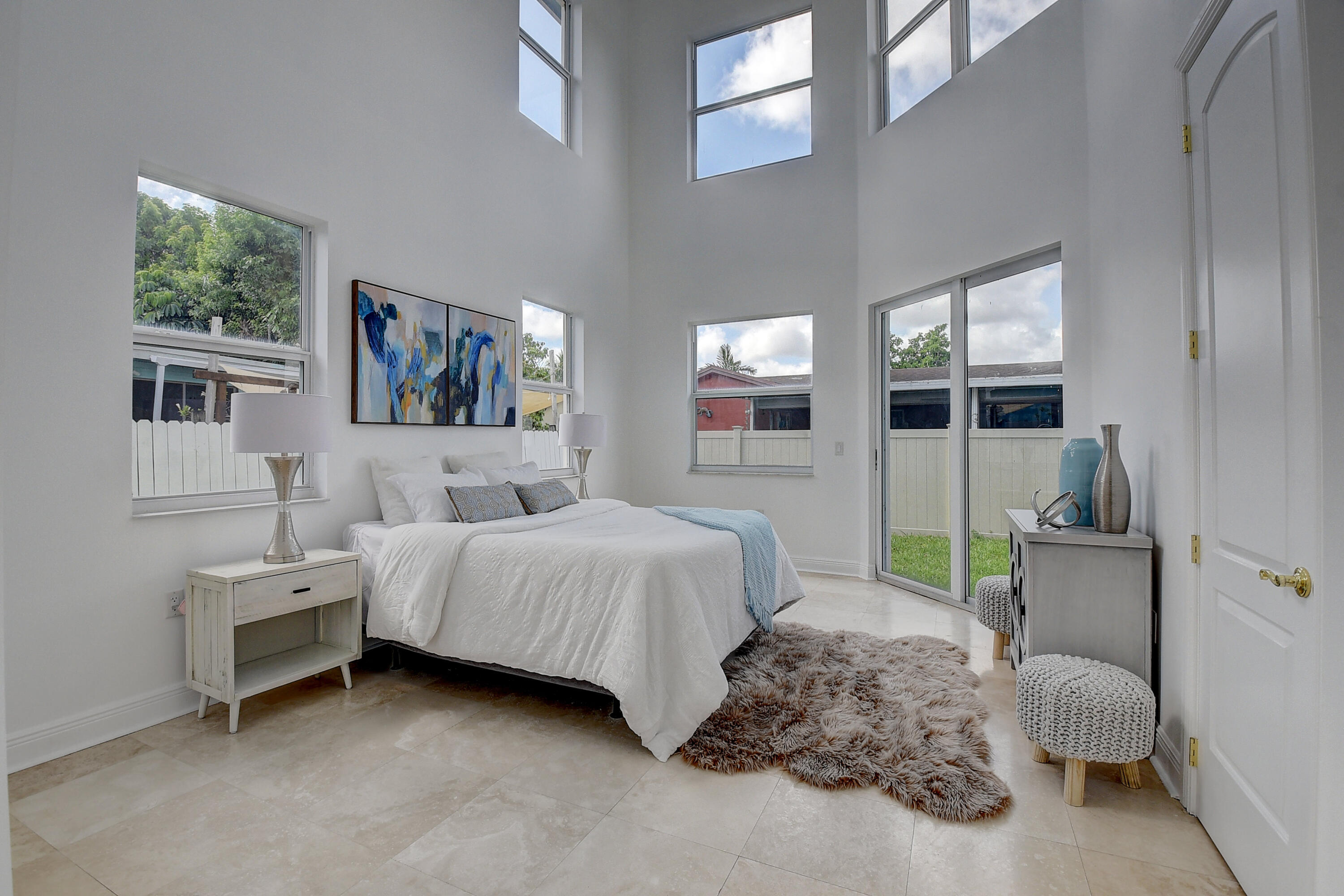 9058 Southwest 4th Street Boca Raton, FL 33433 - Photo 20 of 53 a spacious bedroom with a bed a couch and large window