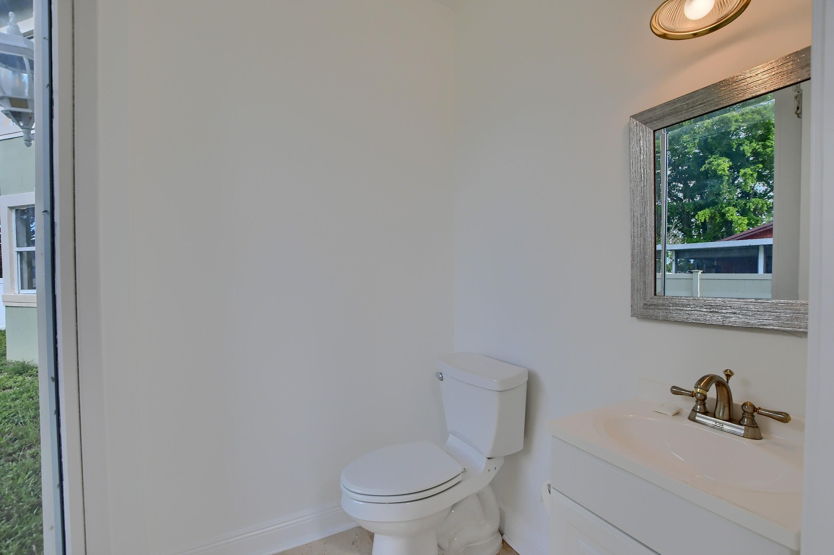 9058 Southwest 4th Street Boca Raton, FL 33433 - Photo 26 of 53 a bathroom with a toilet a sink and a window