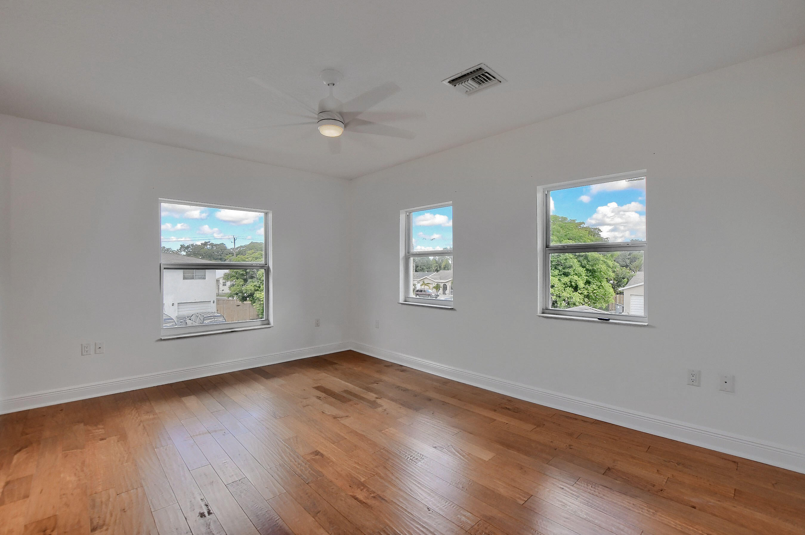 9058 Southwest 4th Street Boca Raton, FL 33433 - Photo 32 of 53 a view of an empty room with wooden floor and a window