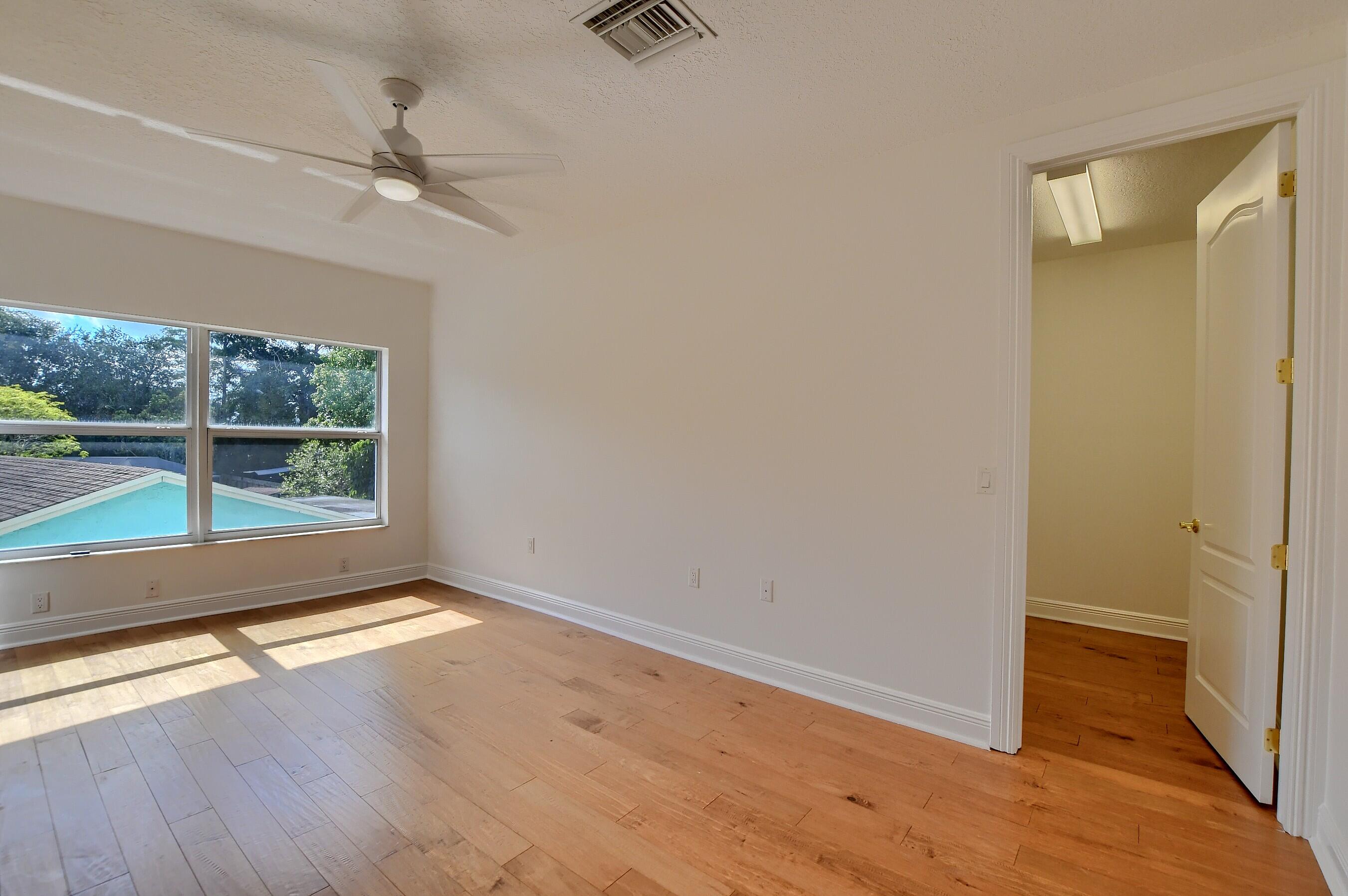 9058 Southwest 4th Street Boca Raton, FL 33433 - Photo 38 of 53 an empty room with wooden floor fan and windows
