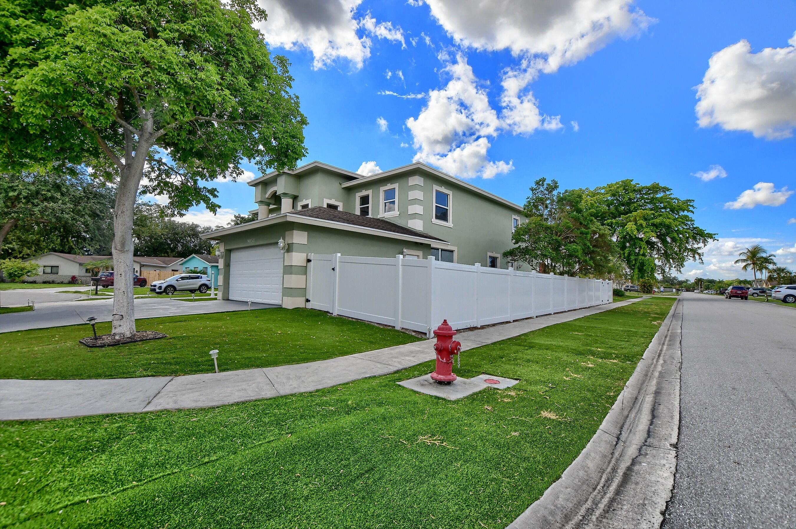 9058 Southwest 4th Street Boca Raton, FL 33433 - Photo 43 of 53 a front view of a house with a yard and garage