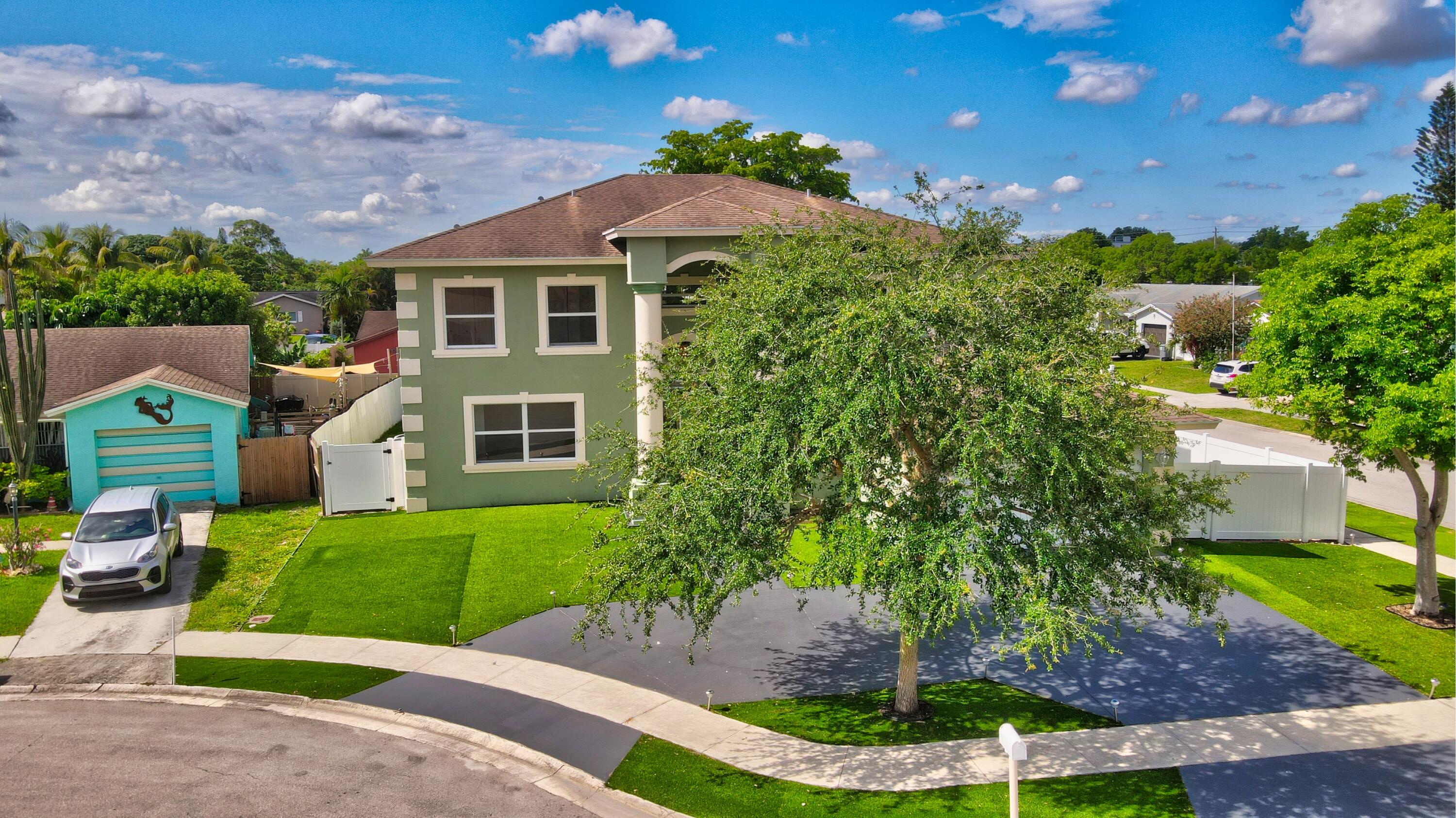 9058 Southwest 4th Street Boca Raton, FL 33433 - Photo 46 of 53 a front view of a house with a yard and garage