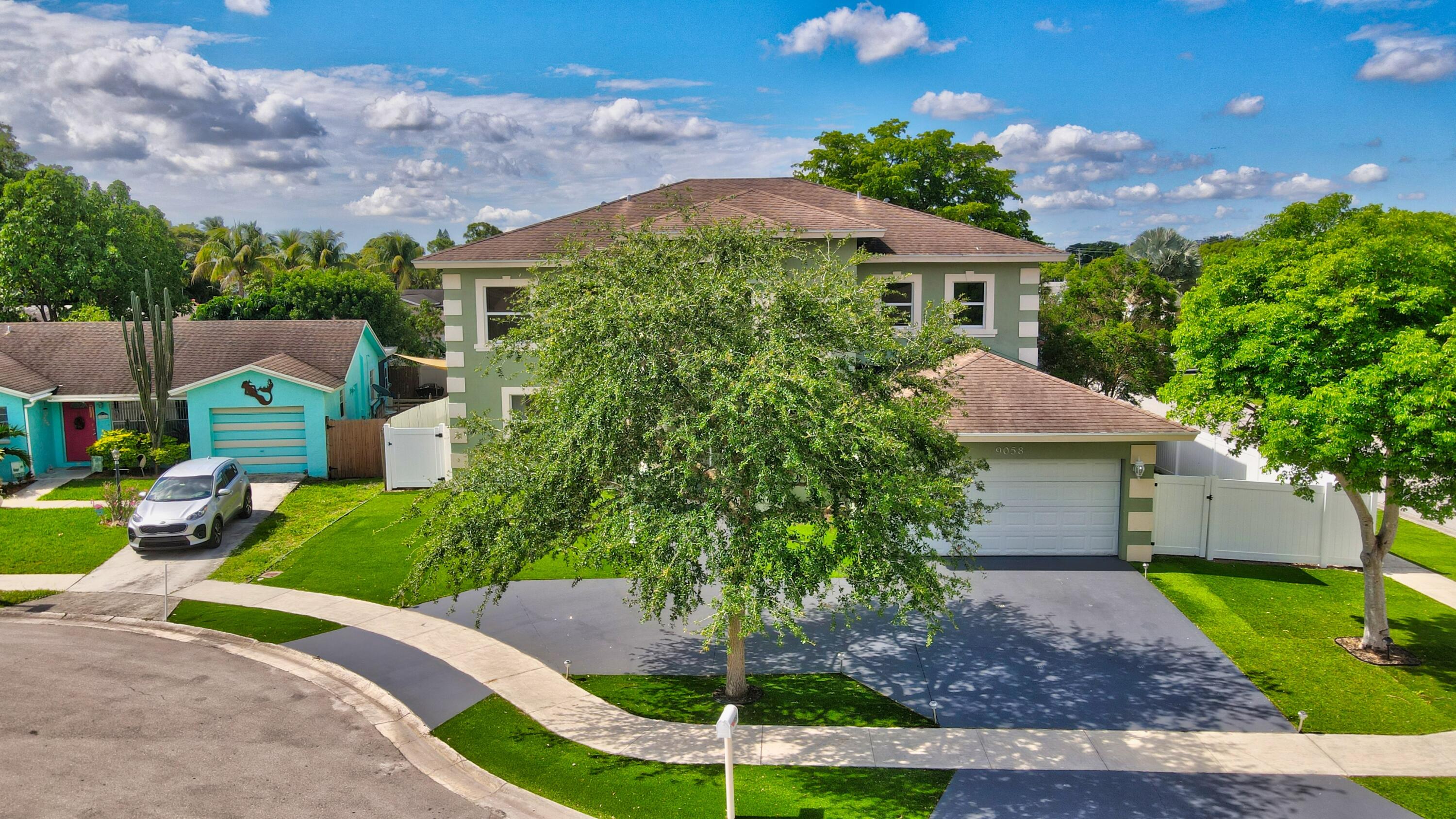 9058 Southwest 4th Street Boca Raton, FL 33433 - Photo 47 of 53 a front view of a house with a yard and garage