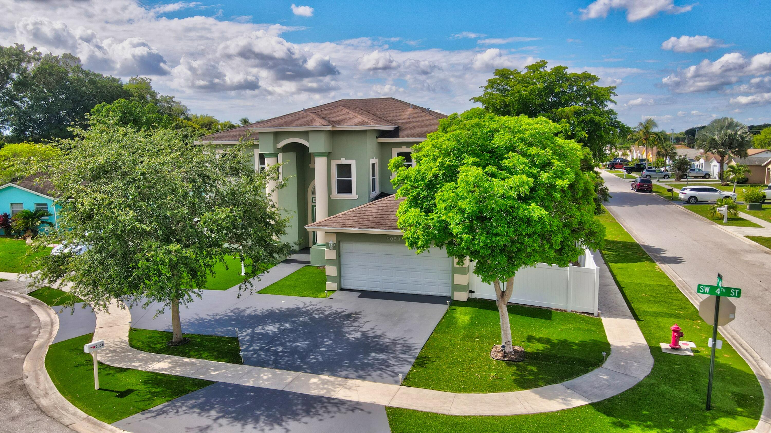 9058 Southwest 4th Street Boca Raton, FL 33433 - Photo 48 of 53 a front view of a house with a yard and potted plants