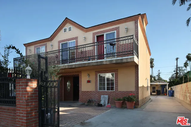 an aerial view of residential houses with outdoor space and parking
