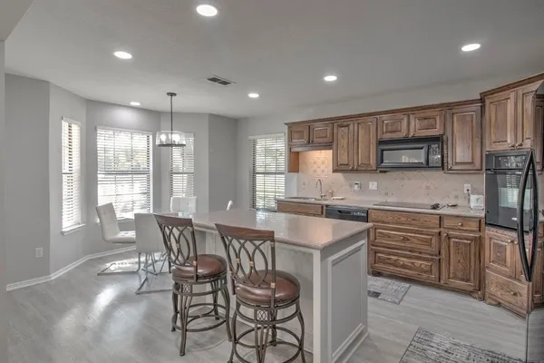 a kitchen with granite countertop a sink and wooden cabinets