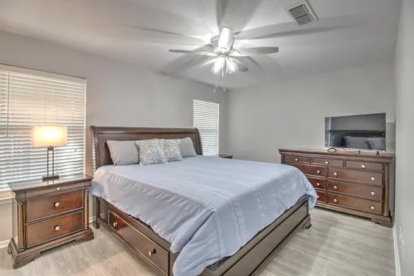 a bedroom with a bed and a flat tv screen on a dresser