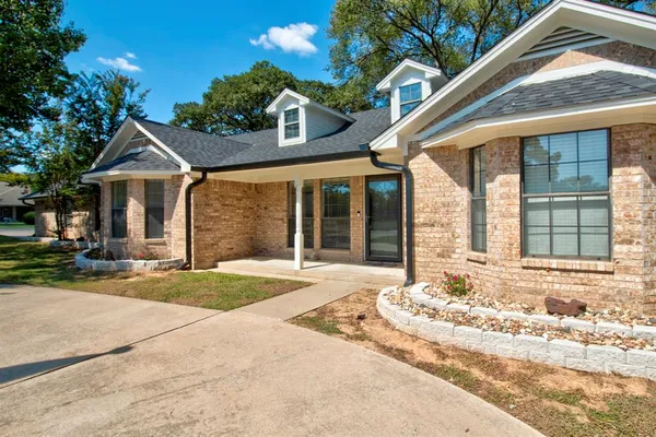 a view of a house with a patio and a yard