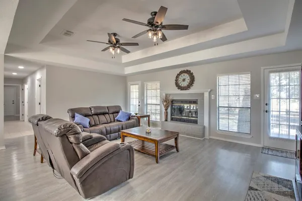 a living room with furniture a fireplace and wooden floor