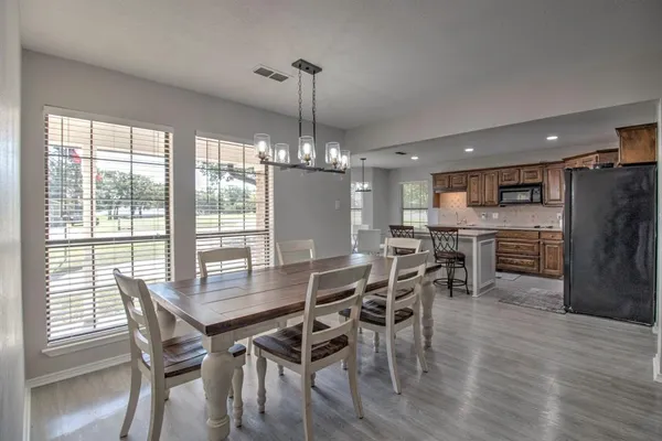 a view of a dining room and livingroom with furniture wooden floor a chandelier