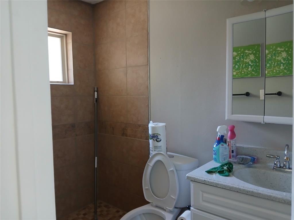 5002 South Prairieview Arlington, TX 76017 - Photo 6 of 11 a bathroom with a sink mirror and toilet