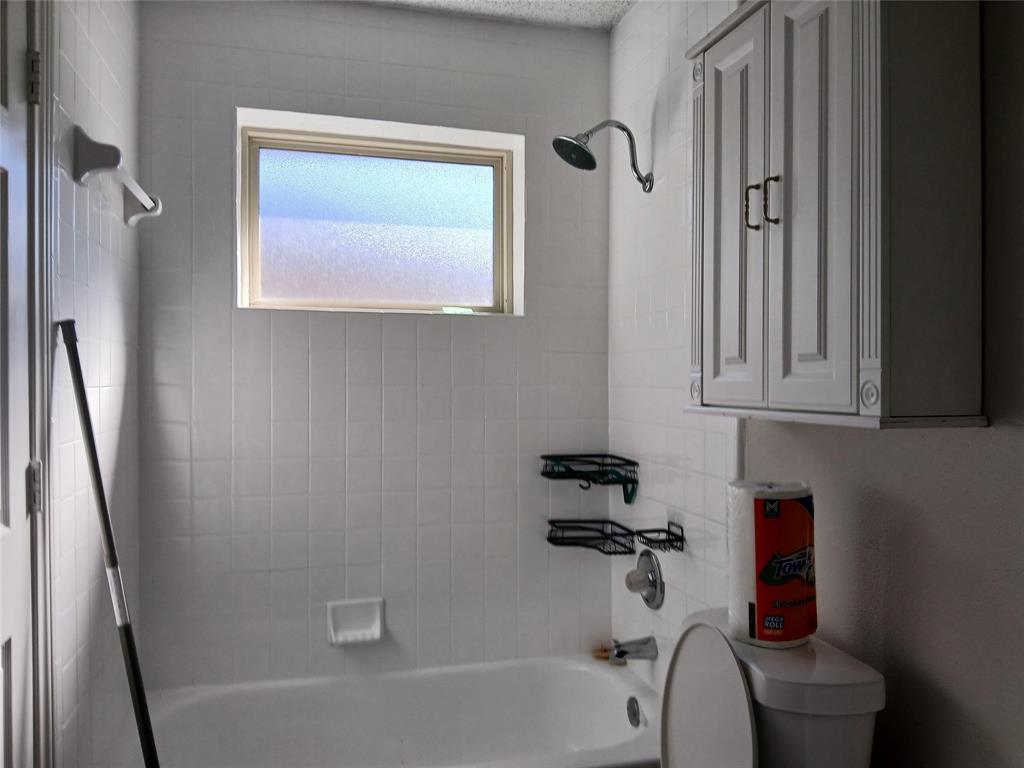 5002 South Prairieview Arlington, TX 76017 - Photo 9 of 11 a bathroom with a bathtub a toilet and a shower