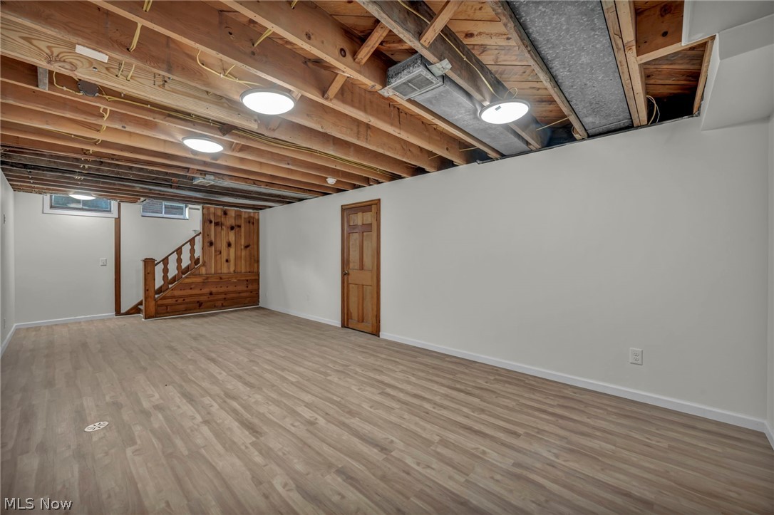 3543 Lytle Road Shaker Heights, OH 44122 - Photo 43 of 49 Spacious lower level featuring wood-finish flooring, white painted walls, and an exposed wood joist ceiling with flush-mount lighting