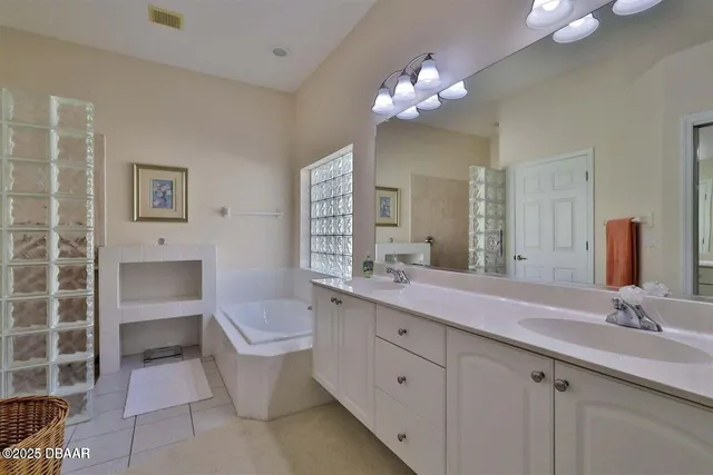 a bathroom with a bathtub a sink and a large mirror