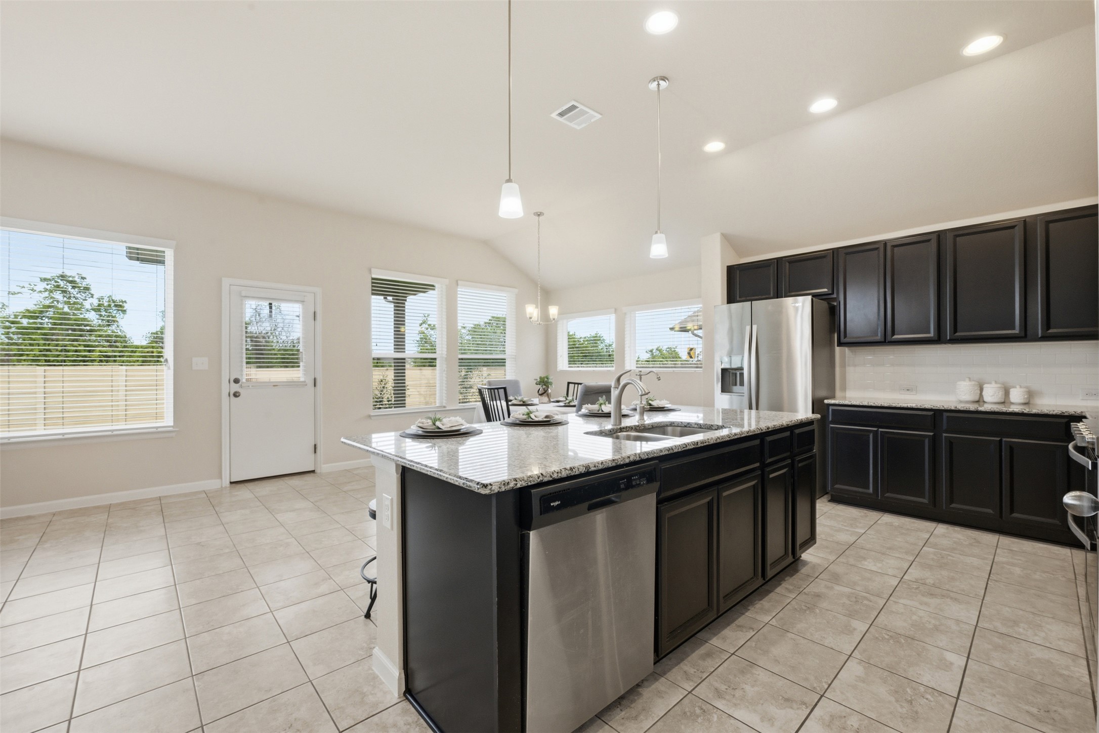 276 Gunnison Way Kyle, TX 78640 - Photo 26 of 28 a kitchen with stainless steel appliances granite countertop a sink counter space cabinets and a large window