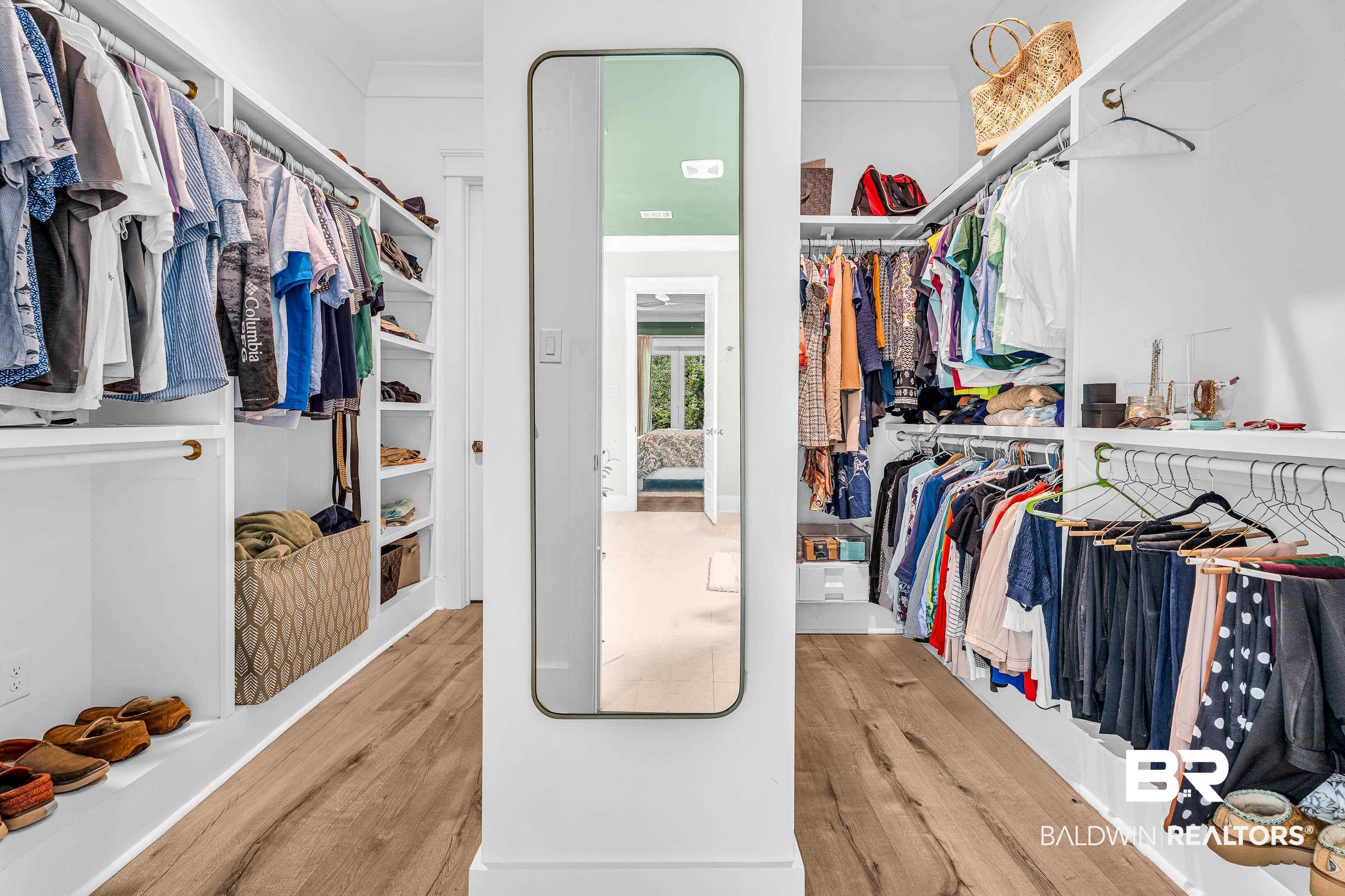 17541 Polo Ridge Boulevard Fairhope, AL 36532 - Photo 15 of 19 Walk-in closet featuring wood-finish flooring, white built-in shelving, hanging rods, and a full-length wall-mounted mirror