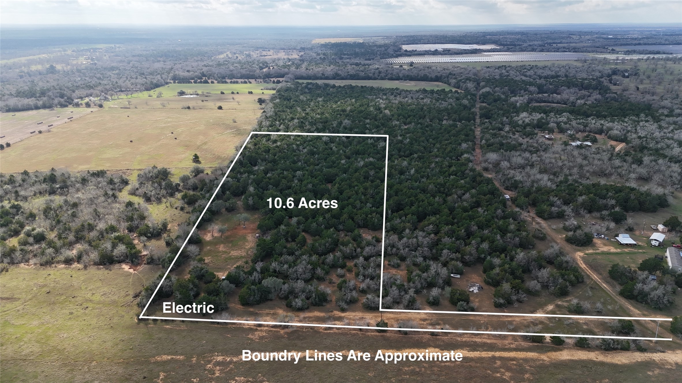 View of rural area featuring property boundaries highlighted and a heavily wooded area