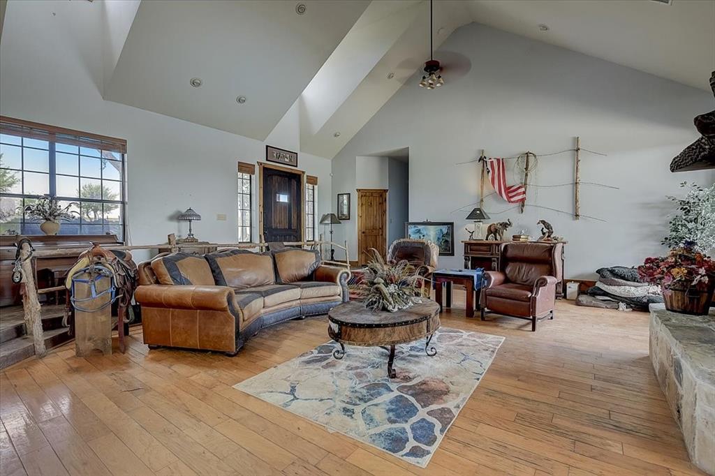9494 Waide Road Sanger, TX 76266 - Photo 9 of 40 Living room with high vaulted ceiling, ceiling fan, and light hardwood / wood- flooring. Living room is open to the Kitchen and formal dining area and has huge picture windows that overlook sparkling pool.