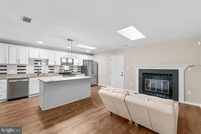 a living room with furniture a fireplace and wooden floor