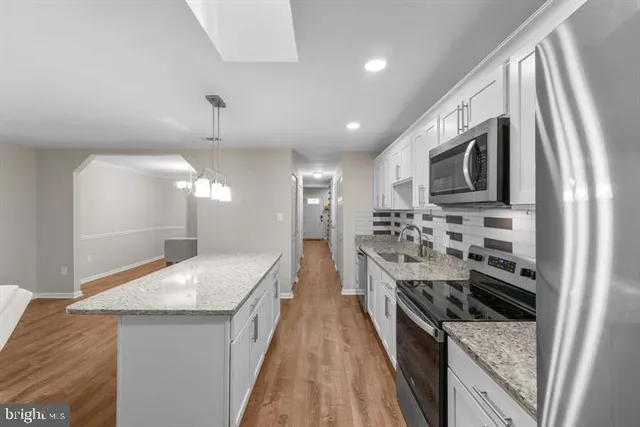 a kitchen with stainless steel appliances granite countertop a sink and stove