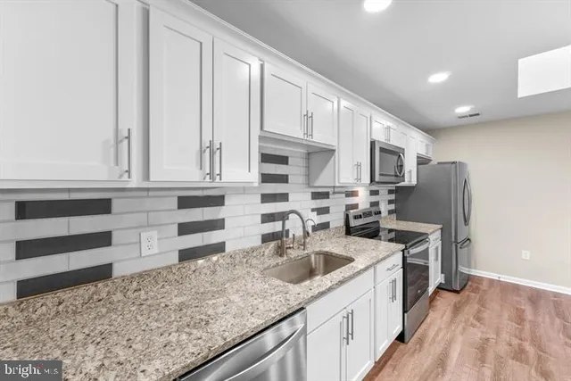 a kitchen that has a lot of cabinets and wooden floor
