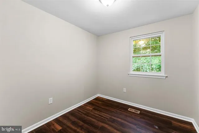 a view of a room with wooden floor and windows