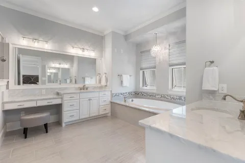 a bathroom with a granite countertop double vanity sink and a mirror
