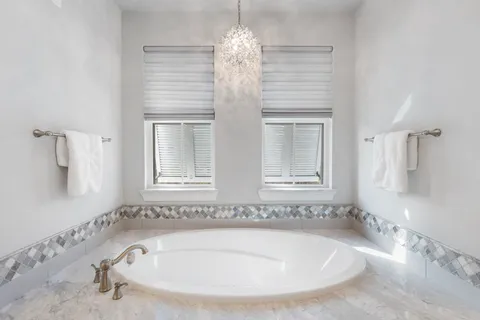 a bathroom with bathtub and window