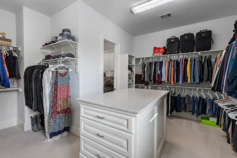 a view of walk in closet with clothes and shoes