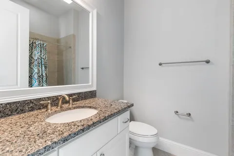 a bathroom with a granite countertop sink and a mirror