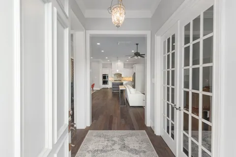 a view of a hallway with wooden floor and a living room